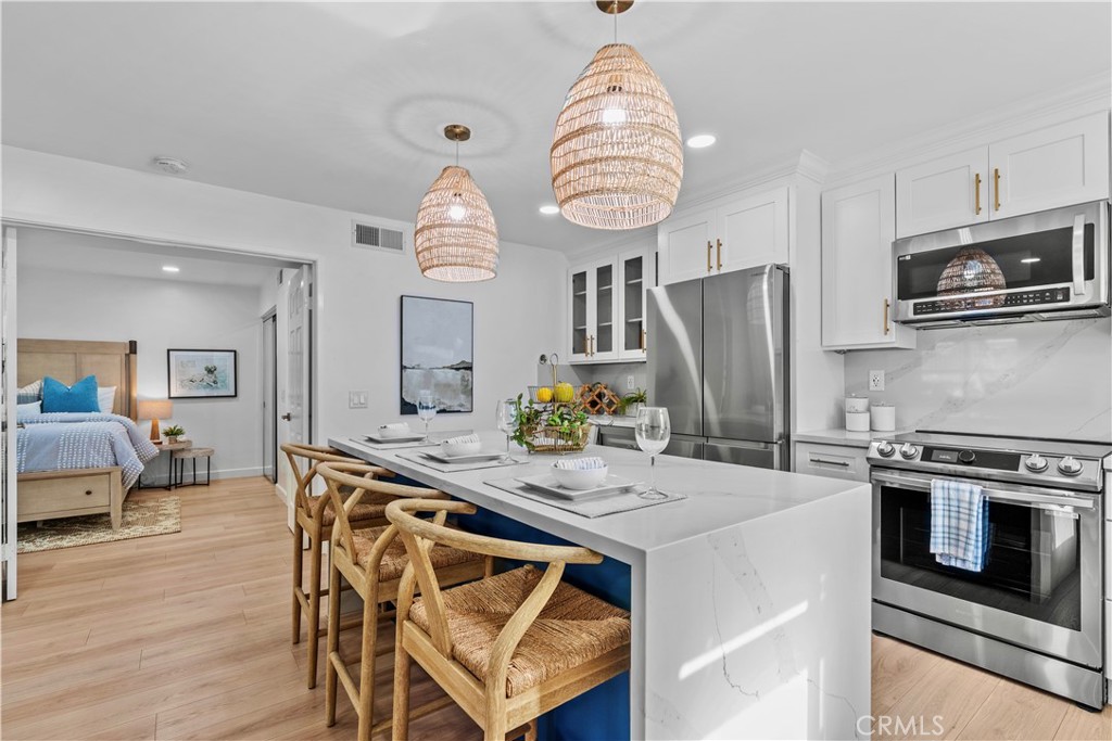 34014 Selva Road, Unit 18 Dana Point, CA 92629 - Photo 1 of 1 a kitchen with stainless steel appliances a table chairs and a refrigerator