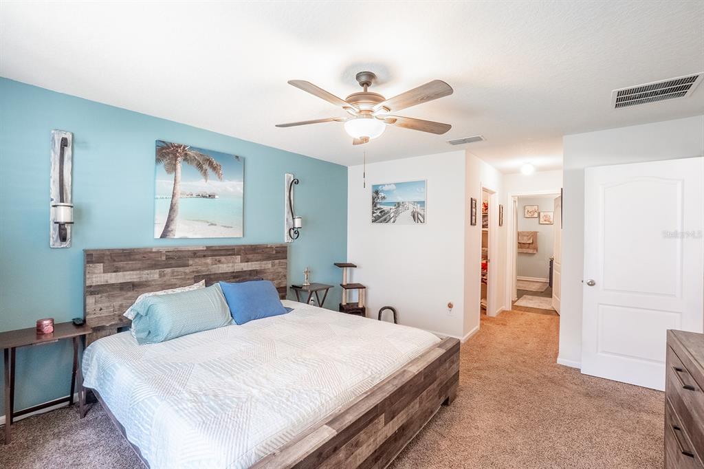 15 Grand Par Court Bunnell, FL 32110 - Photo 26 of 61 a bedroom with a bed and a chandelier