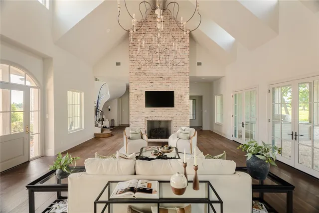 a open kitchen with stainless steel appliances granite countertop a stove top oven a refrigerator a dining table and chairs with wooden floor