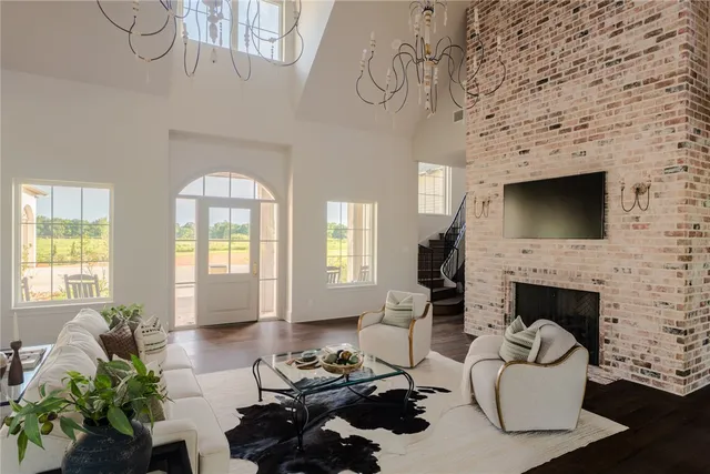 a living room with furniture a fireplace and a chandelier