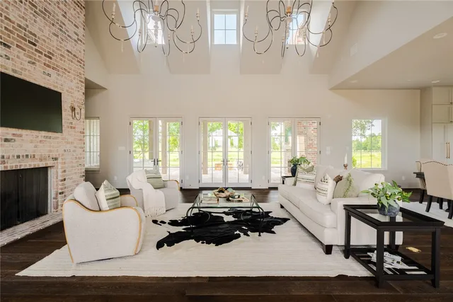 a kitchen with stainless steel appliances a stove a sink dishwasher a refrigerator white cabinets and wooden floor