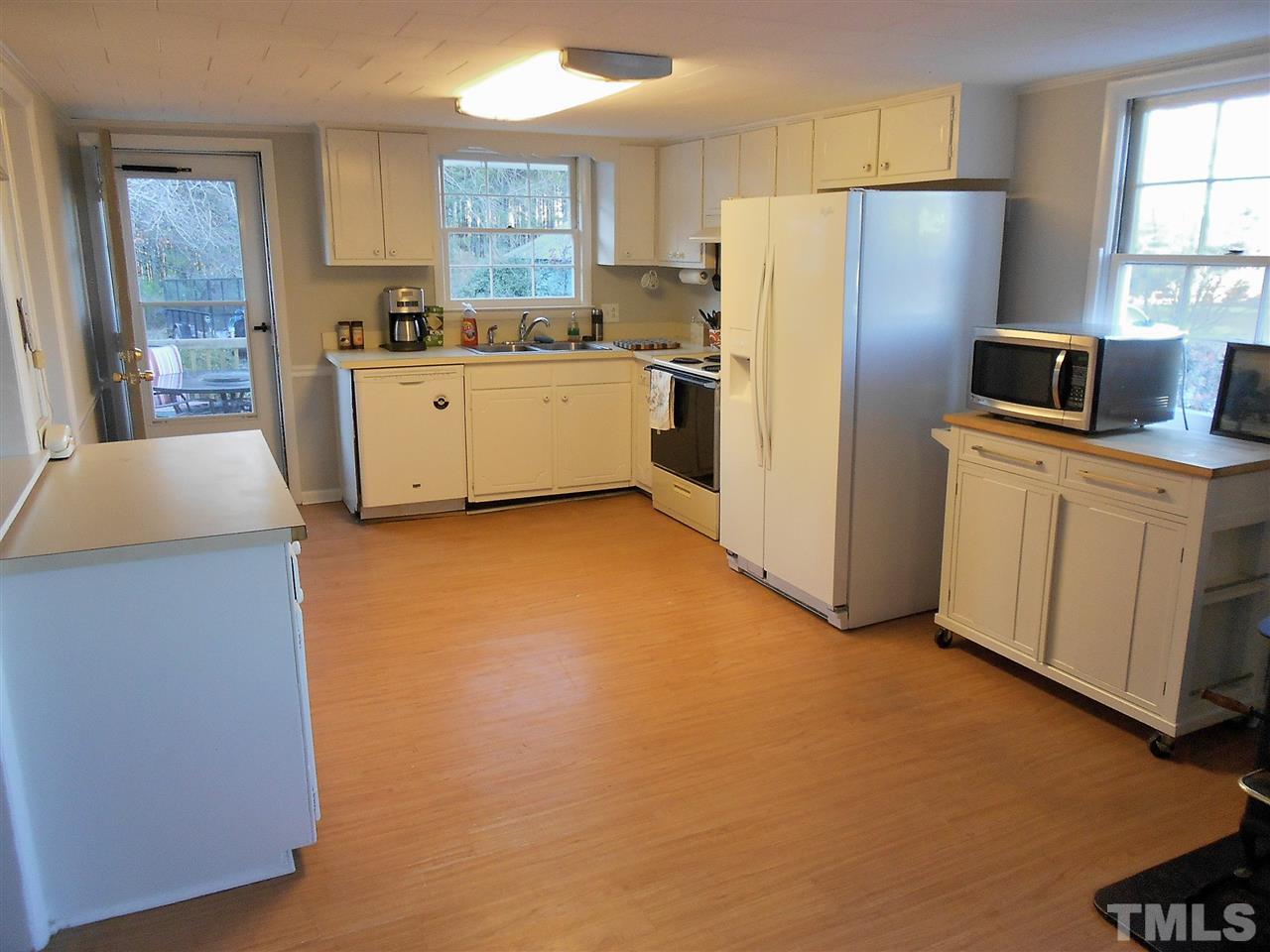 9408 Walter Myatt Road Fuquay-Varina, NC 27526 - Photo 5 of 25 a kitchen with stainless steel appliances a refrigerator sink and white cabinets