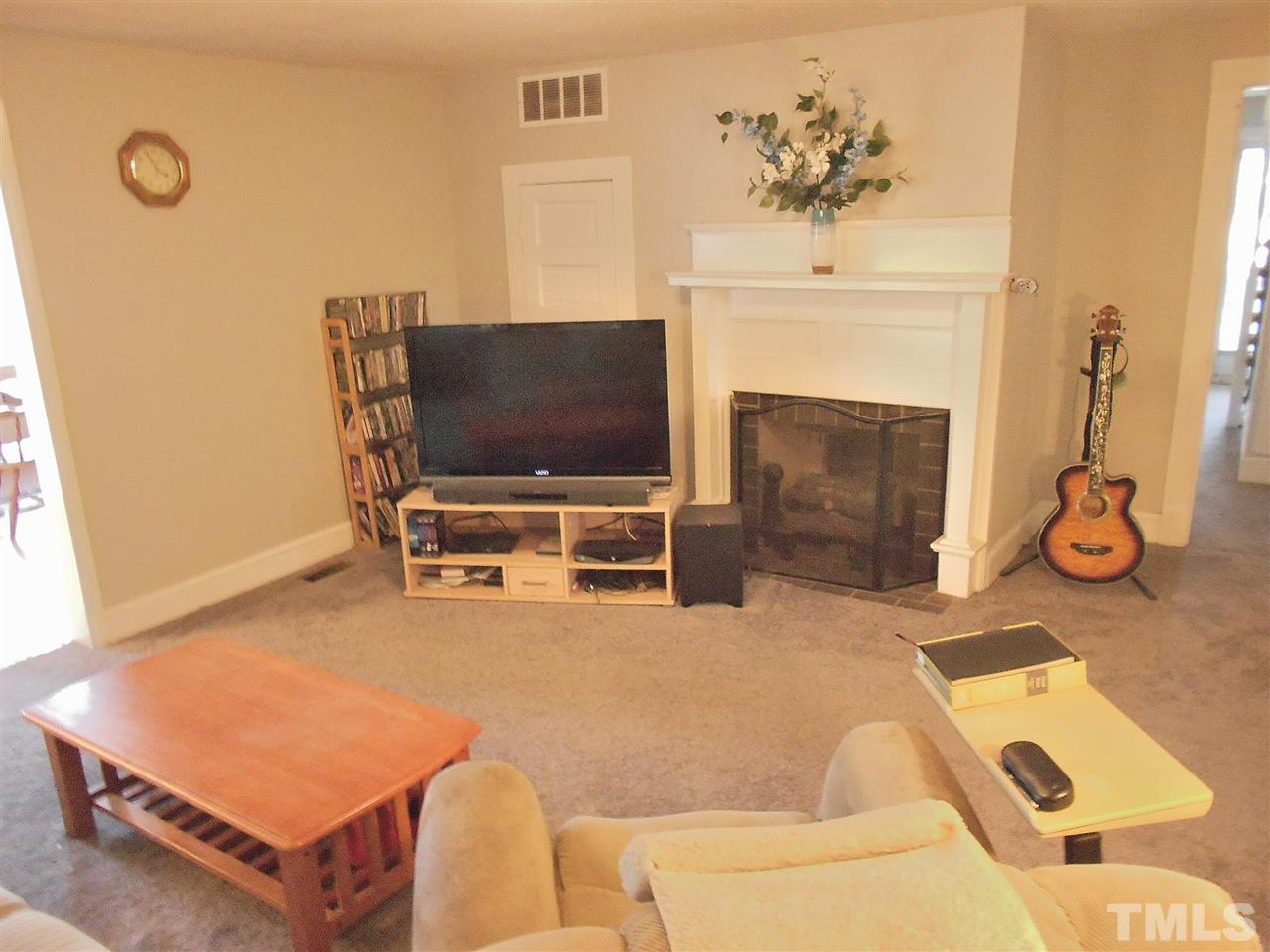 9408 Walter Myatt Road Fuquay-Varina, NC 27526 - Photo 9 of 25 a living room with furniture a flat screen tv and a fireplace