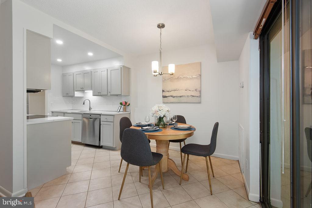 11600 Stoneview Square, Unit 60/2B Reston, VA 20191 - Photo 4 of 27 a kitchen with a dining table chairs and cabinets