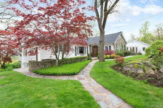 a front view of a house with a yard and potted plants