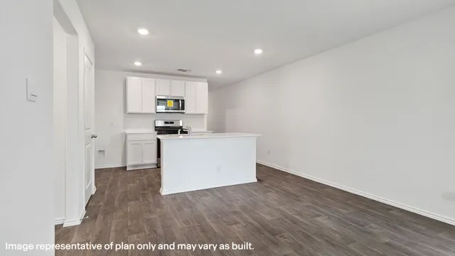 a view of a kitchen with refrigerator and wooden floor