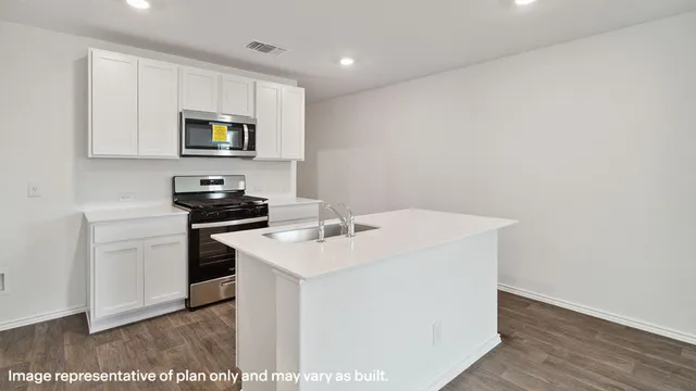 a kitchen with a sink a microwave and cabinets