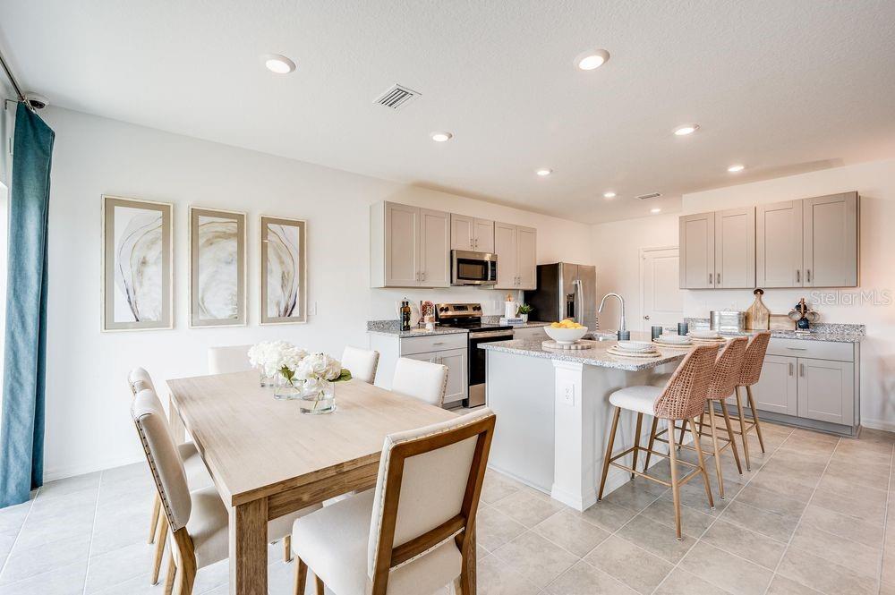 12486 Whisk Court Hudson, FL 34669 - Photo 6 of 29 a kitchen with a dining table chairs and refrigerator
