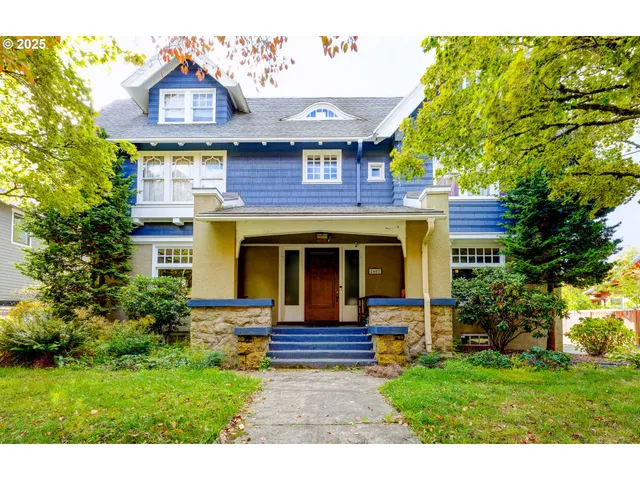 a view of a brick house with a large window and a yard
