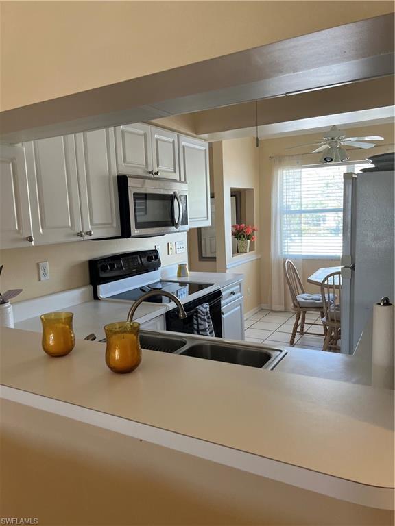 185 Grand Oaks Way, Unit R204 Naples, FL 34110 - Photo 8 of 18 a kitchen with a stove a refrigerator and cabinets