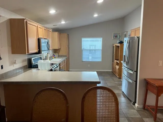a kitchen with a sink a counter top space cabinets stainless steel appliances and a window