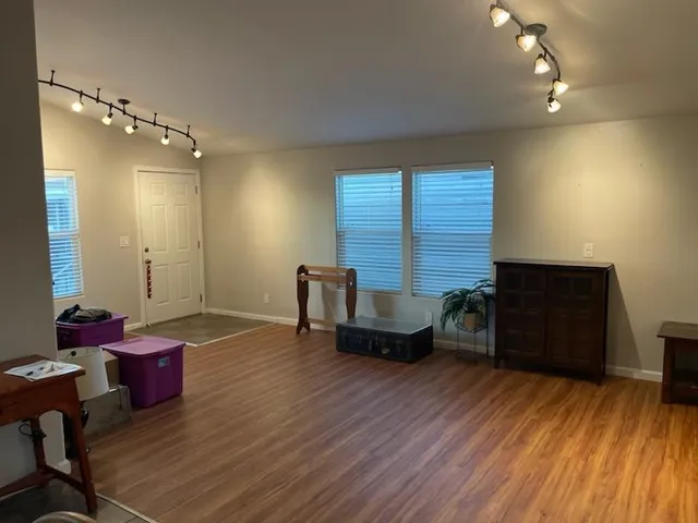 a living room with furniture and a wooden floor