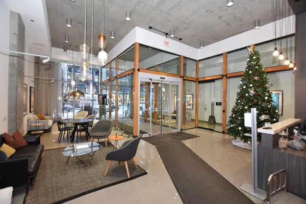 a large living room with stainless steel appliances furniture wooden floor and a large window