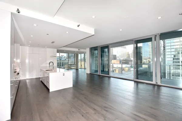a large white kitchen with a large window appliances and cabinets