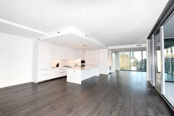 a kitchen with white cabinets and wooden floor