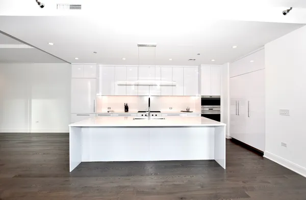 a kitchen with a sink a stove and white cabinets
