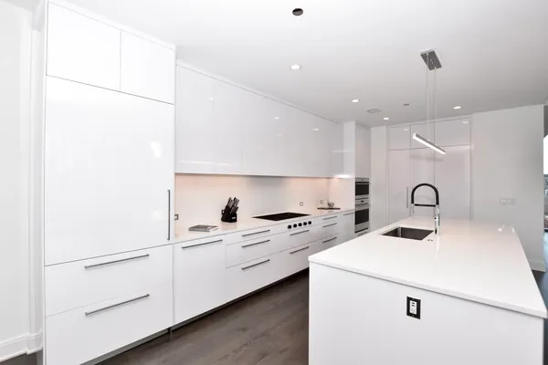 a kitchen with kitchen island a white counter top space appliances and a sink