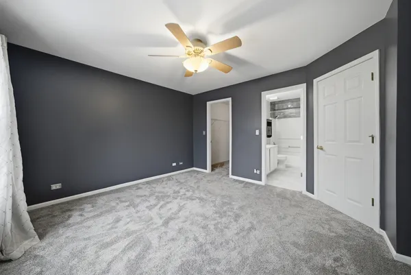an empty room with closet and a ceiling fan