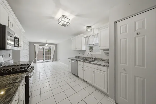 a kitchen with stainless steel appliances granite countertop a stove a sink and a refrigerator