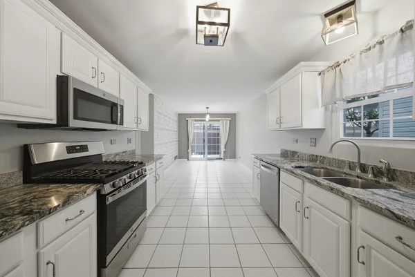 a kitchen with stainless steel appliances granite countertop a stove sink and cabinets