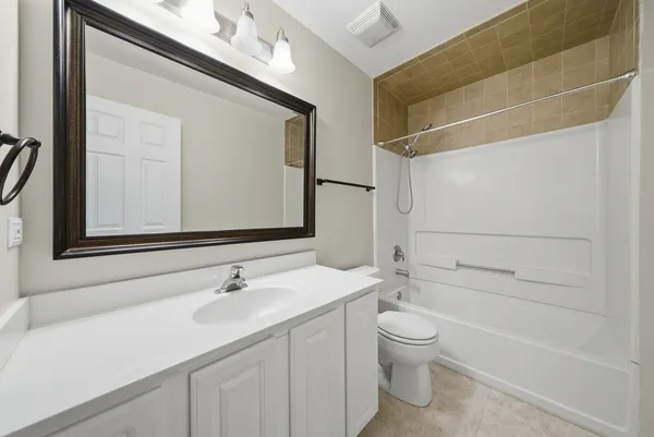 a bathroom with a granite countertop sink a toilet and a bathtub