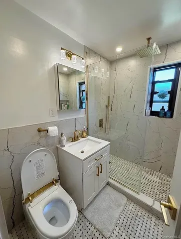 a bathroom with a toilet sink washing machine and mirror