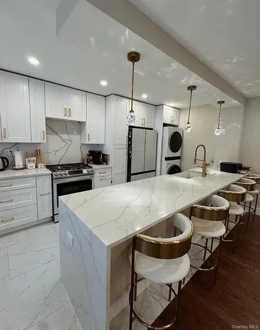 a kitchen with a dining table chairs refrigerator and microwave