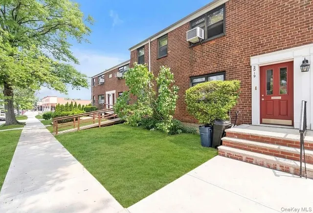 a front view of a house with a yard and potted plants