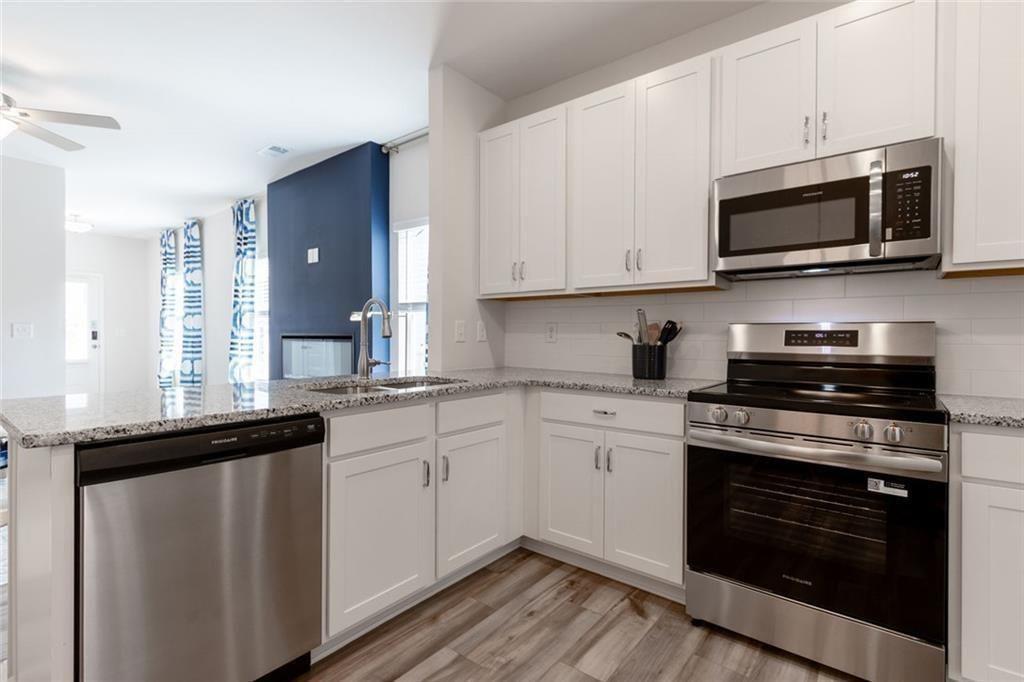 141 Andros Loop Dalton, GA 30721 - Photo 6 of 25 a kitchen with stainless steel appliances granite countertop a stove a microwave and a sink