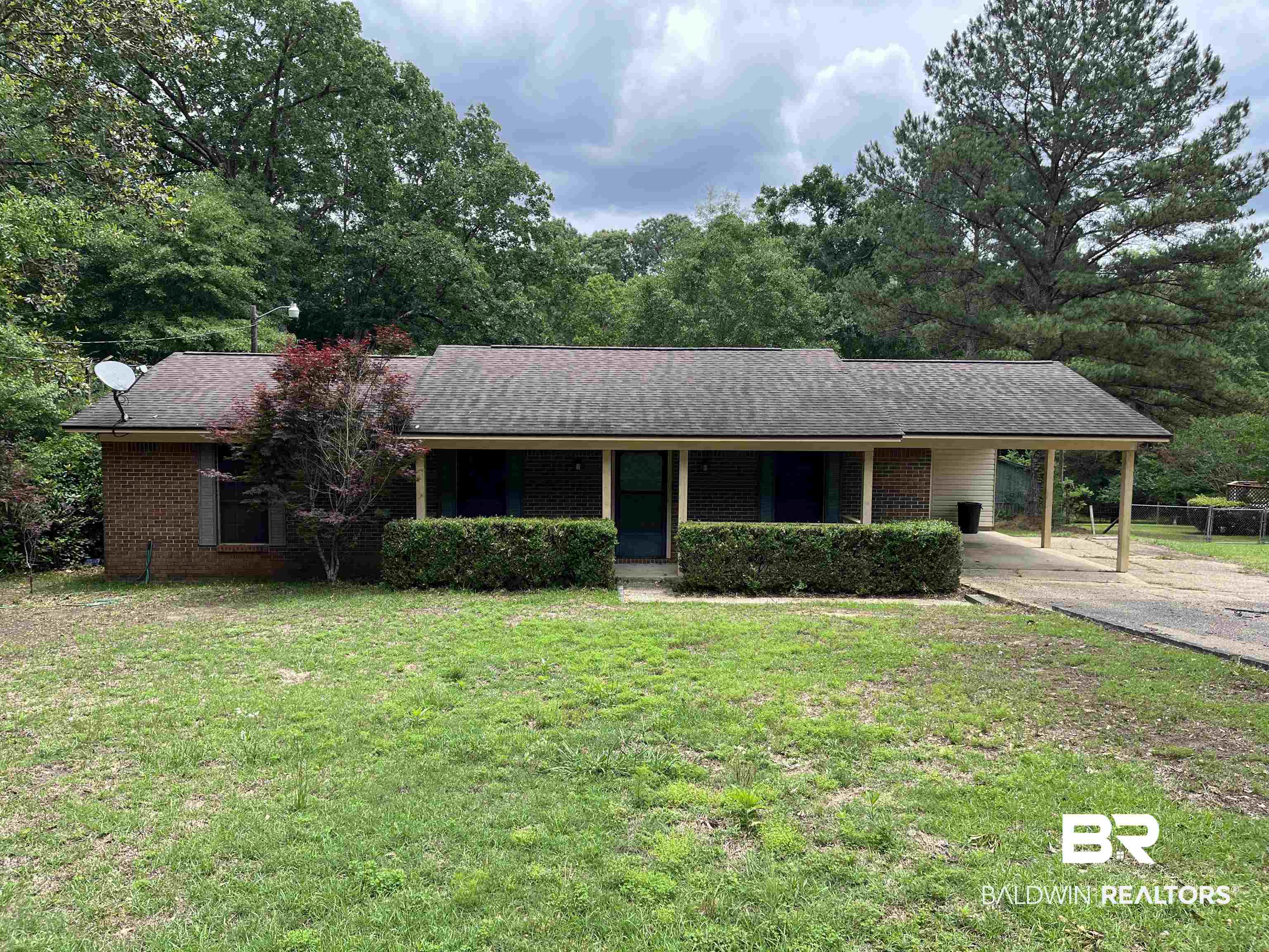 1905 Rockaway Creek Road Atmore, AL 36502 - Photo 1 of 23 Brick facade residence with a dark shingle roof and a covered front porch