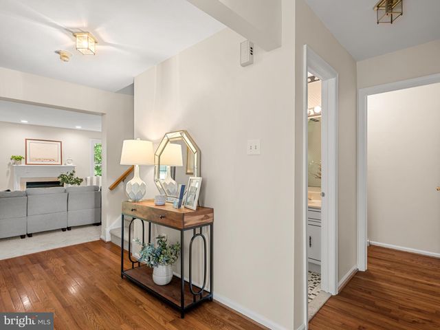 a view of a hallway with wooden floor and furniture
