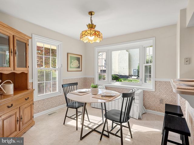 a dining room with wooden floor a chandelier a wooden table and chairs