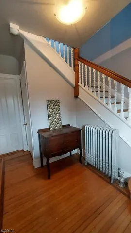a view of staircase with wooden floor and a rug