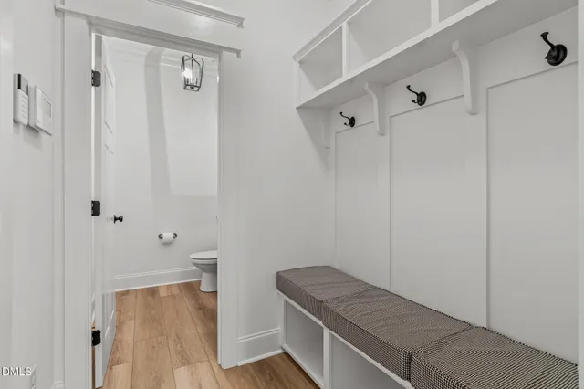 a view of an empty room with wooden floor fireplace and windows