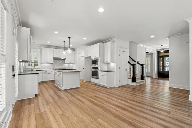 a kitchen with granite countertop a sink a counter space appliances and cabinets
