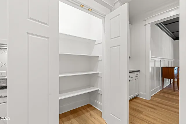 a view of a hallway with wooden floor and staircase
