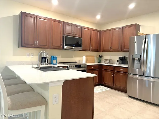 a kitchen with stainless steel appliances granite countertop a refrigerator stove top oven a sink and dishwasher