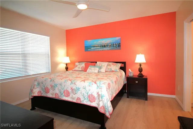 a bedroom with a bed and flat tv screen on dresser