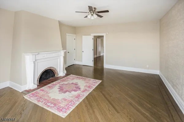 a view of a livingroom with a fireplace a chandelier and wooden floor