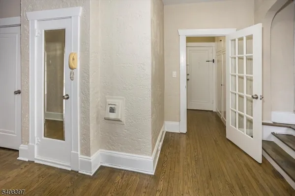 a view of a hallway with wooden floor and staircase