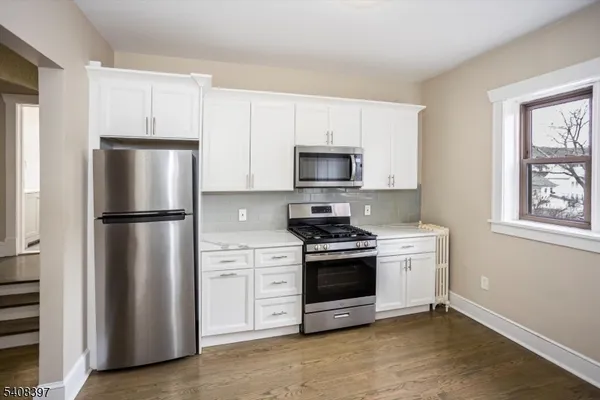 a kitchen with stainless steel appliances a refrigerator stove and microwave