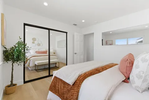 a bedroom with a bed and a potted plant