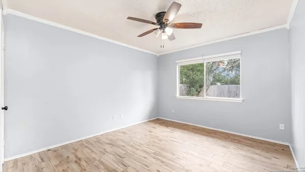 an empty room with a window and a fan