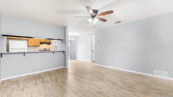 a view of a kitchen with wooden floor and a ceiling fan