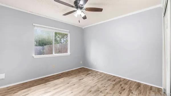 an empty room with a window and a fan