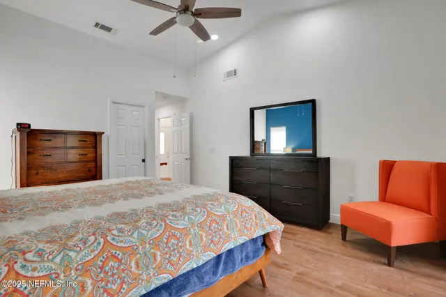 a bedroom with a bed and wooden floor