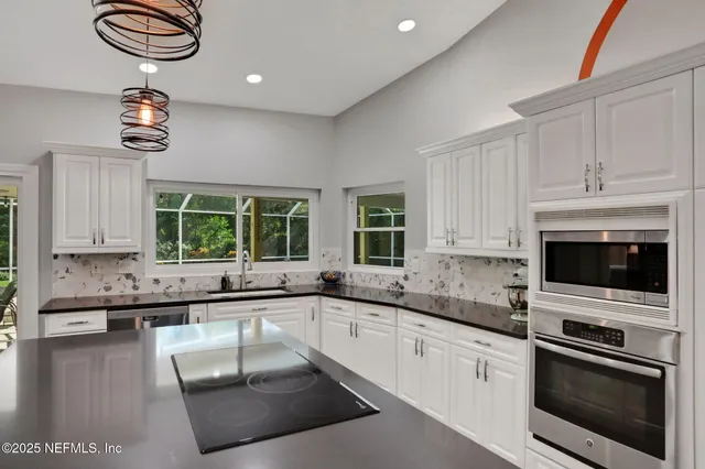 a large kitchen with kitchen island a sink appliances and a counter space