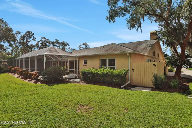 an aerial view of residential houses with outdoor space and trees
