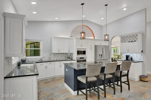 a living room with furniture a flat screen tv and a floor to ceiling window