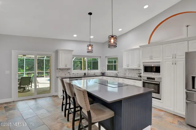 a living room with furniture kitchen view and a chandelier